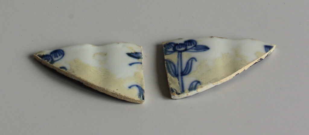 Detail van de scherven van de schotel voor de behandeling. Duidelijk zichtbaar is de verkleurde overschildering.